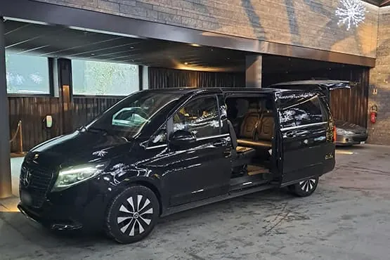 Van Mercedes noir avec porte latérale ouverte et sièges beiges